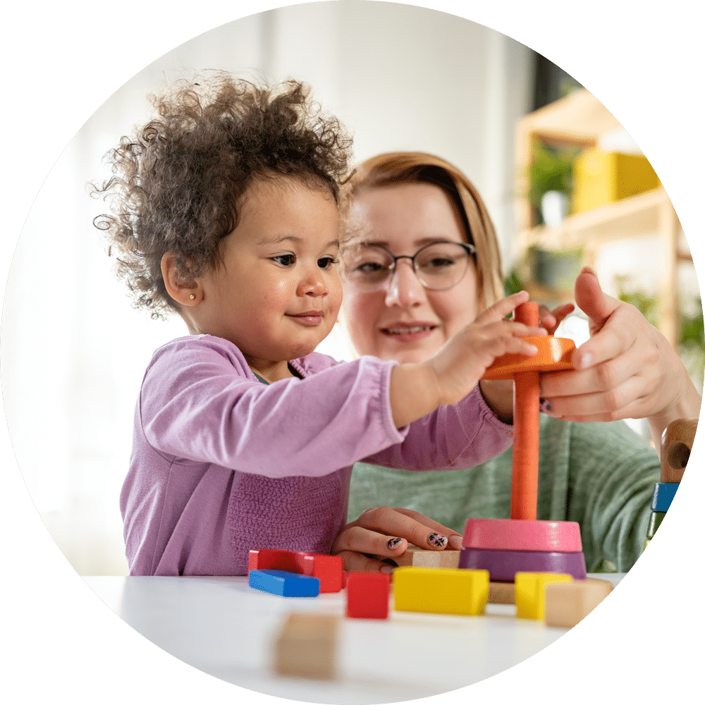 Mutter und Tochter spielen fröhlich mit Holzspielzeug